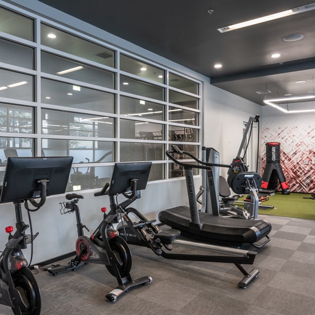 Domain Oakland Apartments - fitness center with cardio equipment and free weights
