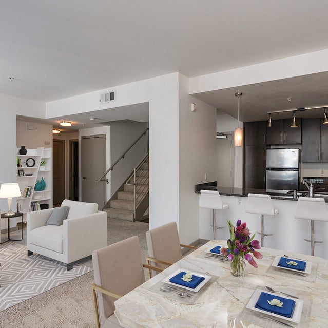 Domain Oakland Apartments - carpeted living room with dining area and kitchen bar